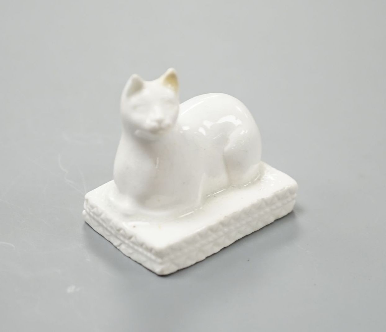 A Derby porcelain model of a cat recumbent on a cushion base, c.1810–25, 3.6 cm long, Cf. Dennis G.Rice, Cats in English porcelain, a variant of colour plate 21., Provenance: Dennis G.Rice collection